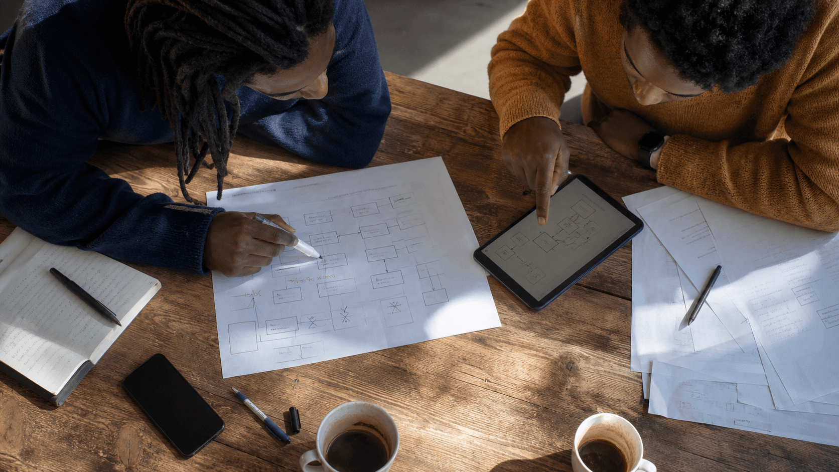 Two colleagues planning media placements around a table