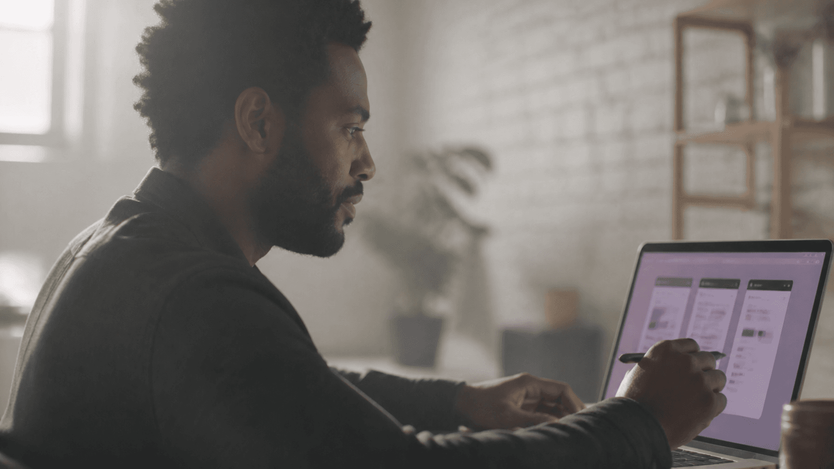 Black man reviewing wireframes on a laptop